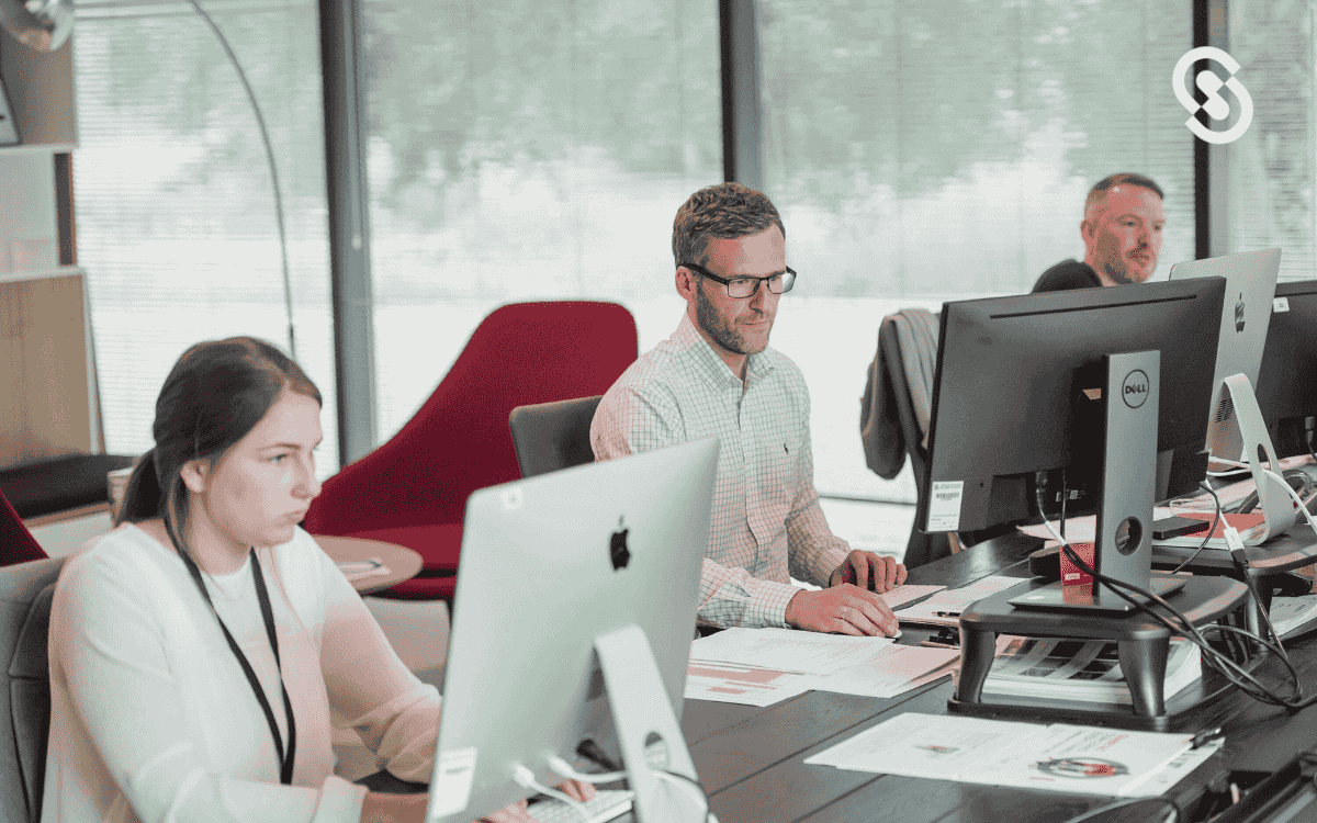 Equipo trabajando en computadoras, demostrando cómo crear un CRM desde cero para mejorar la gestión de relaciones con clientes y procesos de ventas.