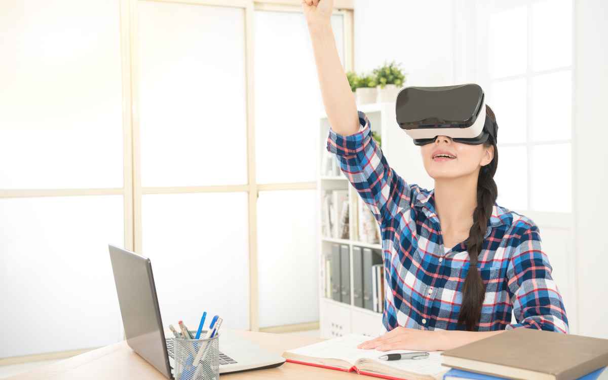 Vemos una alumna de un curso en modalidad e-learning utilizando herramientas de realidad virtual. 