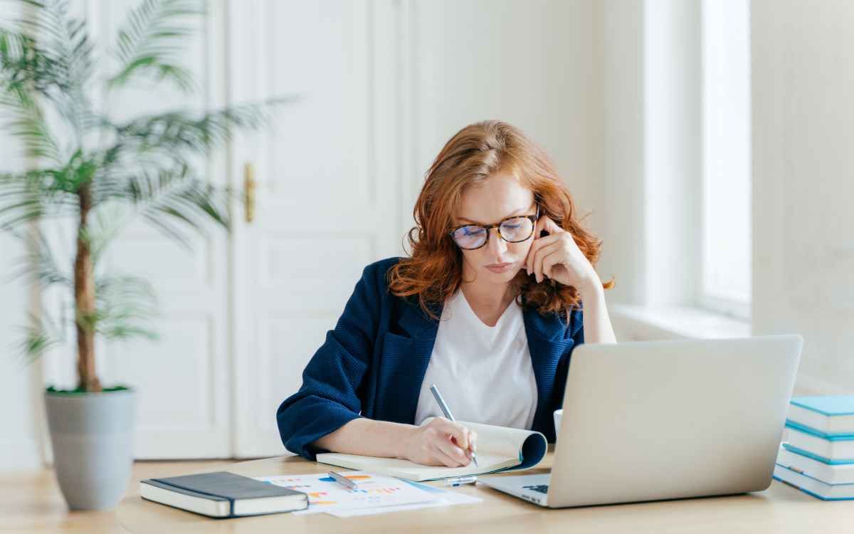 Vemos una persona haciendo anotaciones sobre un webinar al que asiste.