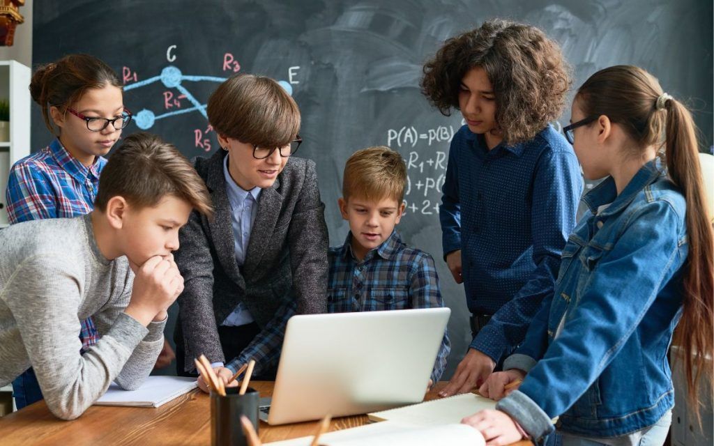 En la imagen se ve a un grupo de chicos utilizando técnicas de aprendizaje cooperativo
