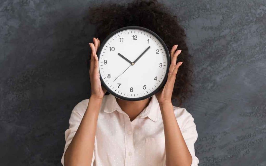 en la imagen vemos a una chica con un reloj simbolizando la gestión del tiempo
