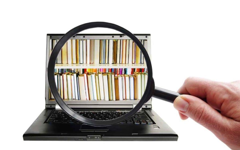 En la imagen se ve a una computadora donde se visualiza la imagen de una biblioteca, para representar la función de una base de conocimiento. 