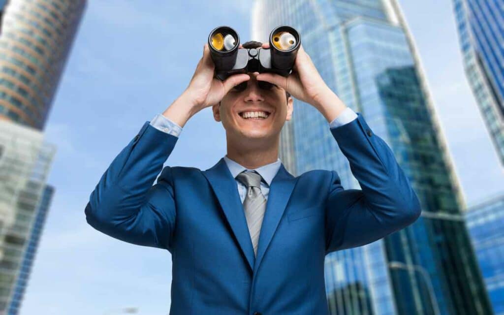 Vemos una imagen de una persona observando al horizonte con binoculares, en referencia a lo que significa el benchmarking.