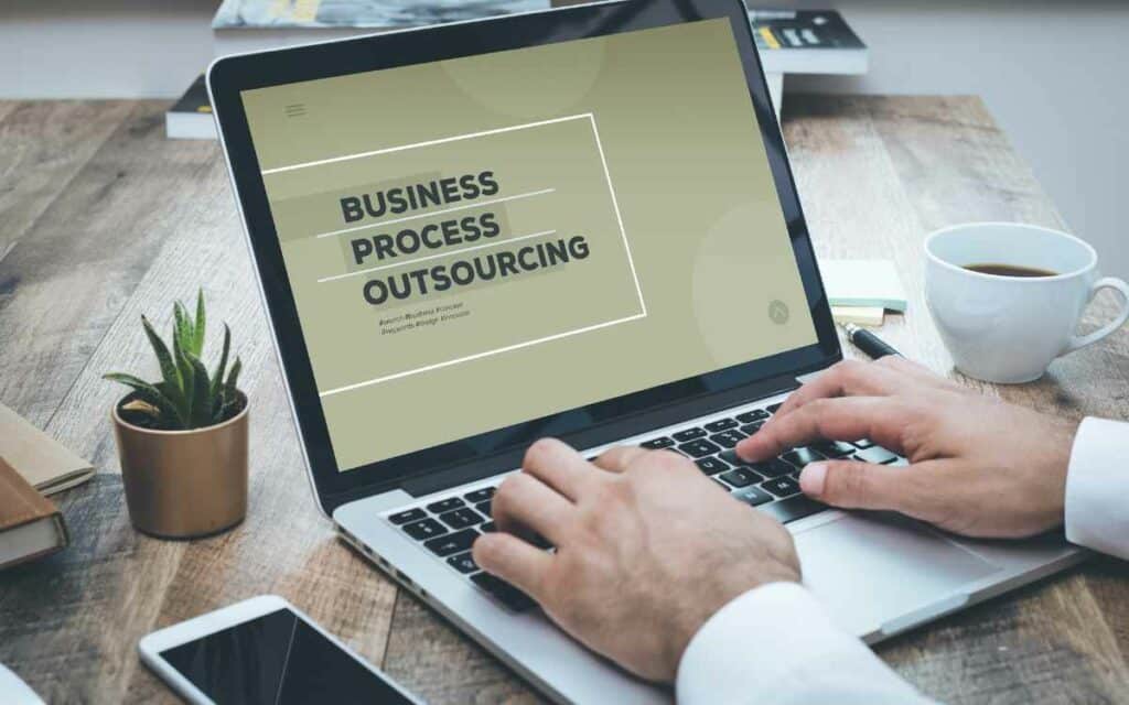 Vemos una imagen de una persona escribiendo en su computadora Bussiness Process Outsourcing.