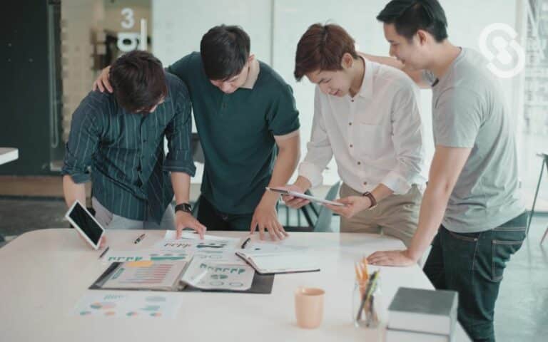En la imagen se ve a un grupo de jovenes diseñando un plan de negocios