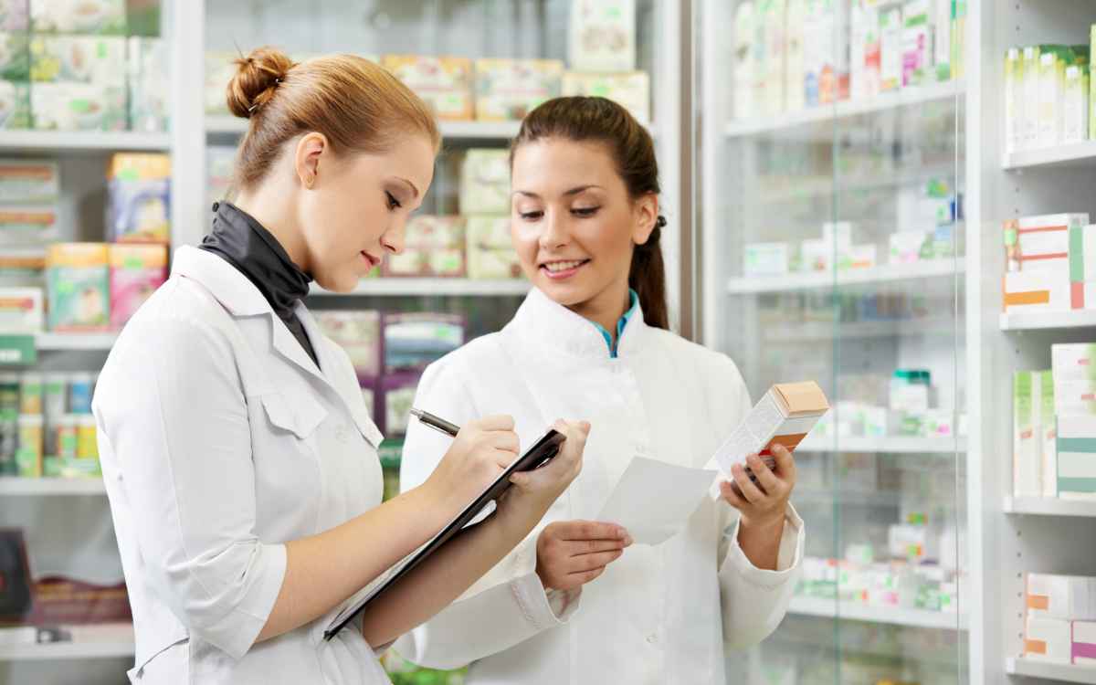 Vemos una imagen de dos empleadas farmacéuticas haciendo el inventario de medicamentos, en relación con los mejores software para farmacias. 