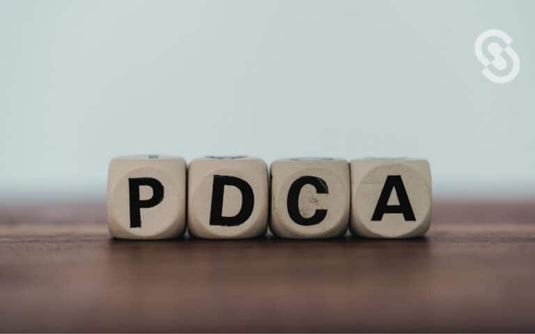 Veos una imagen de las siglas PDCA en cubos de madera, en referencia al ciclo PDCA y su implementación.