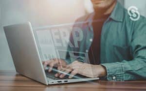 Vemos una persona usando su computadora con las siglas ERP, en referencia a las características de un ERP.