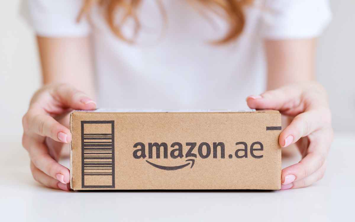 Vemos una imagen de una persona sosteniendo una caja de la compañía Amazon, en relación con los ejemplos de SCM.