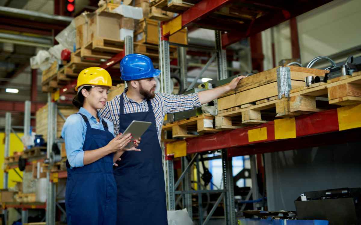 Vemos dos personas encargadas del almacén de una empresa controlando el sistema de inventarios mínimos y máximos.